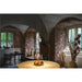 Interior with white pendant lights, round gold tablecloth, brick walls, and arched ceilings.
