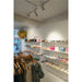 Boutique interior with clothing rack, shelves of shoes and handbags in various colors.