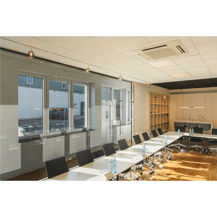 Modern conference room with a long white table, black chairs, glass walls, and wood floor.