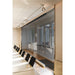 Glass wall with stainless steel hardware and track lighting in a conference room.