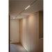 Modern hallway with light wood cabinets, track lighting with white spotlights, and light wood flooring.