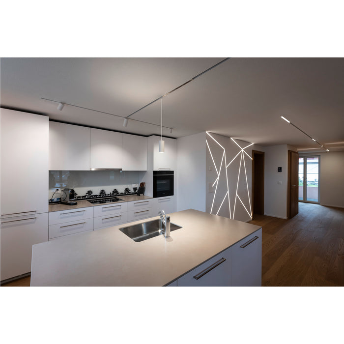 Modern kitchen interior with white cabinets, stainless steel sink, and geometric LED wall lighting.