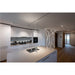 Modern kitchen interior with white cabinets, stainless steel sink, and geometric LED wall lighting.