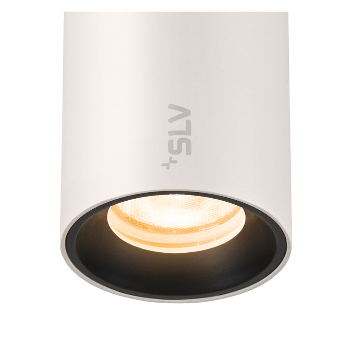 White aluminum cylinder surface-mounted downlight with black baffle.
