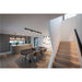 Modern kitchen and dining area with gray cabinets, dark table, upholstered chairs, and light wood stairs.
