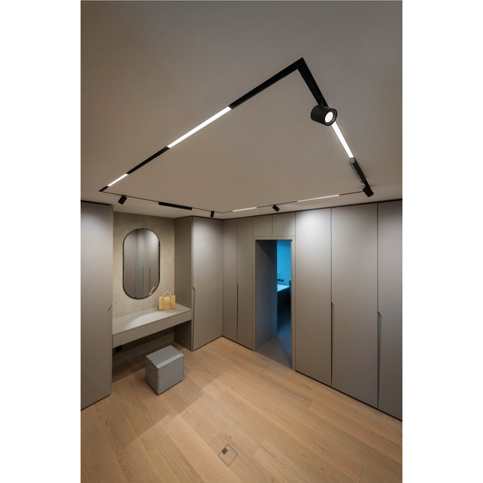 Modern walk-in closet with black track lighting, gray cabinets, wood floor, and vanity with oval mirror.