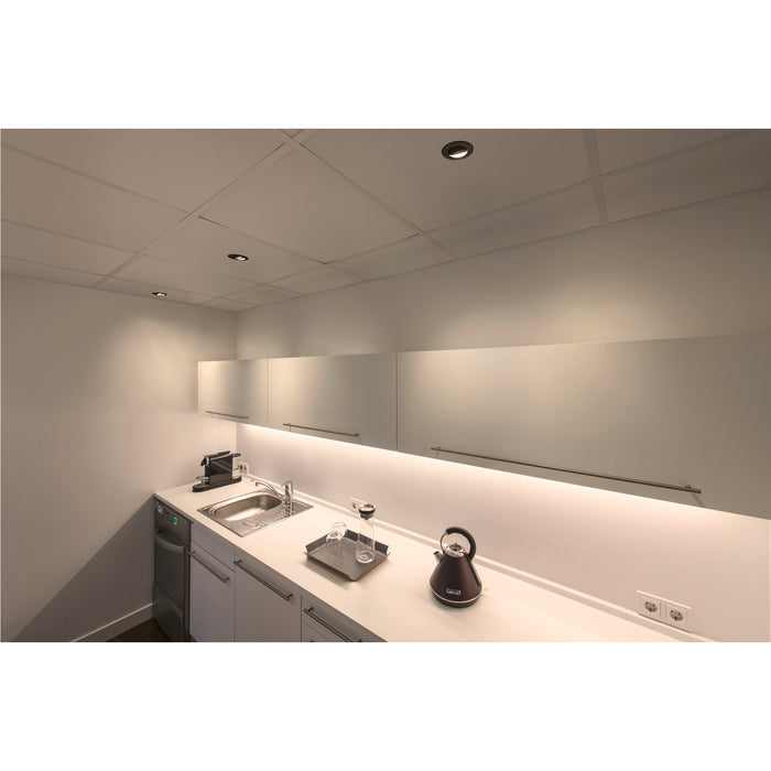 Modern kitchenette with white cabinets, stainless steel sink, and a purple electric kettle on a white countertop.