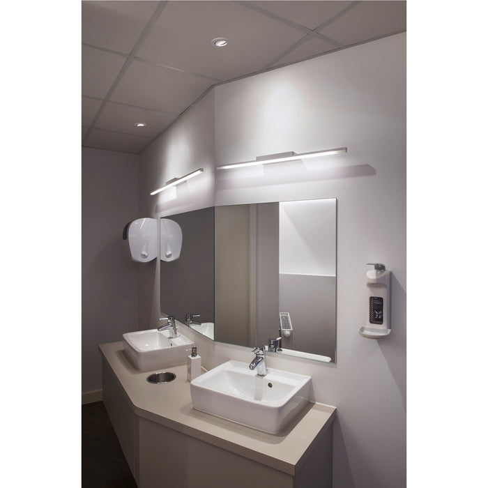Modern bathroom with white ceramic sinks, wall-mounted chrome faucets, and linear LED vanity lights.