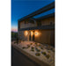Modern home exterior with wood and stone siding, black trim, and two mounted outdoor wall lights.