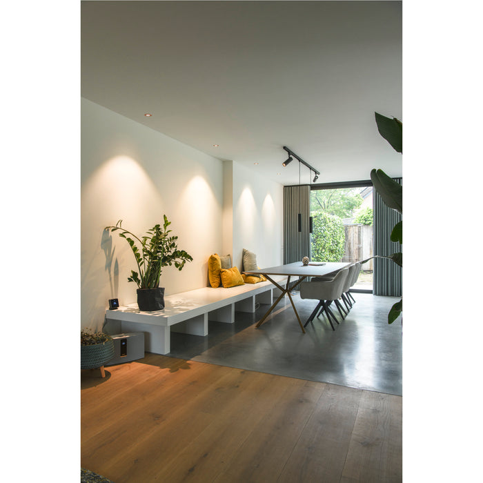 Modern dining room with white bench seating, gray table with gold legs, and gray upholstered chairs.