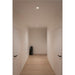 Hallway with light wood floors, white walls and doors, recessed lighting, and a dark stone Moai statue.