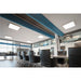 Modern office interior with recessed square LED panel lights, black leather chairs, and a conference table.