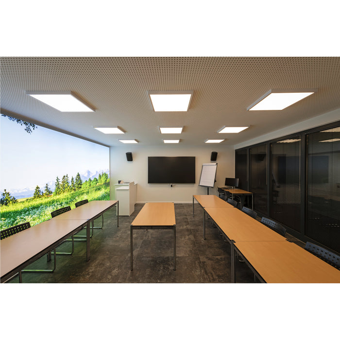 Conference room with wood tables, metal legs, black chairs, and recessed square LED ceiling lights.