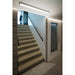 Concrete stairs with black metal handrail, white walls, and recessed linear lighting.