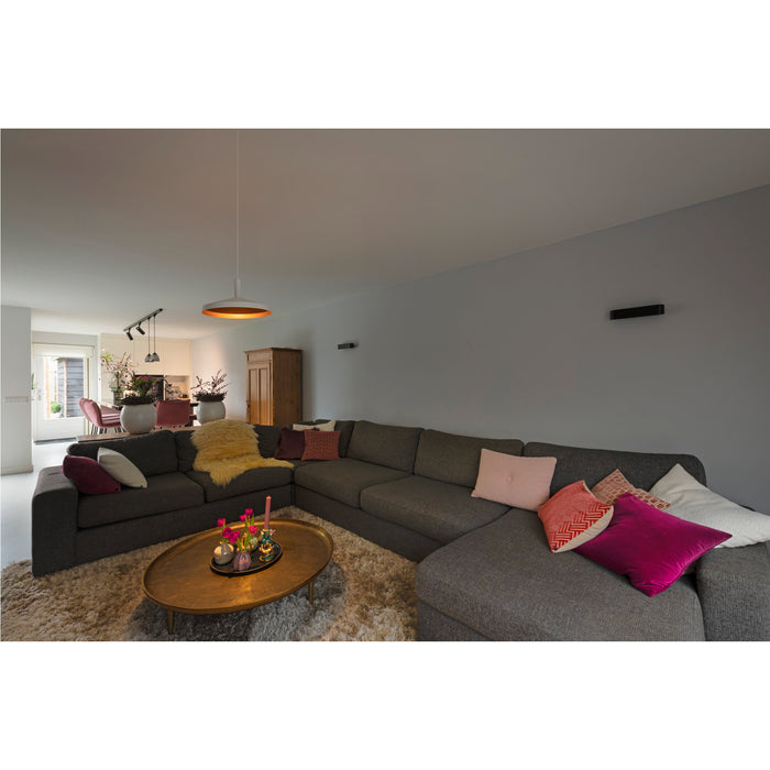 Gray fabric sectional sofa with throw pillows on a shag rug.