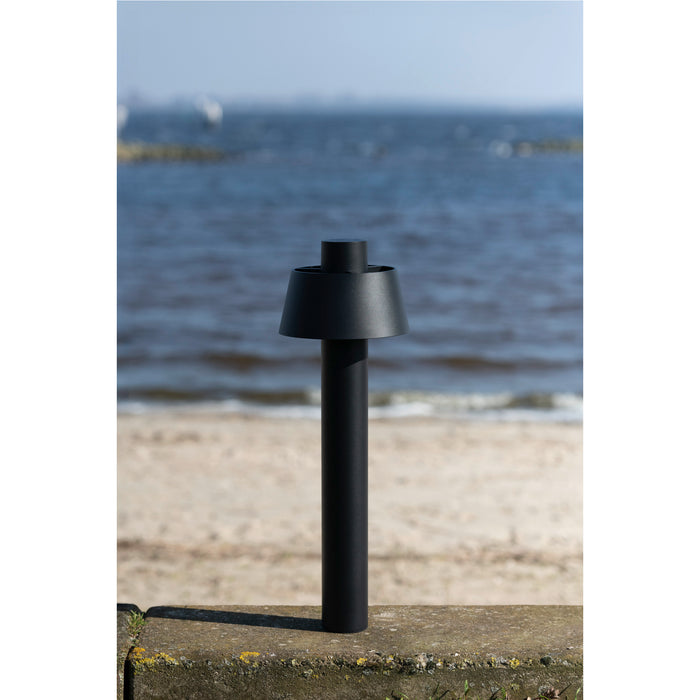 Black metal bollard light with a matte finish, surface mounted.