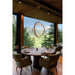 Modern ring chandelier, wood and LED, suspended over a round wood dining table with green velvet chairs.