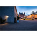 Exterior view of a brick chateau with blue turrets and gravel driveway at dusk.