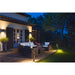 Outdoor patio with dark brown wicker furniture, white cushions, and black metal post lights.