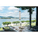 Hanging glass pendant light with black accents over a set table with a lake view.