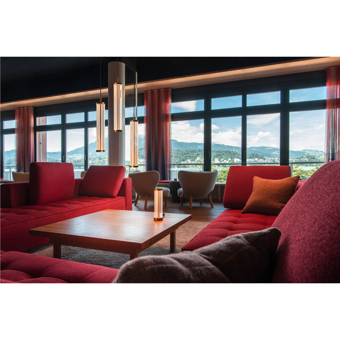 Modern ribbed glass pendant lights with bronze finish in a red-themed lounge.