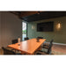 Conference room with wood table, black chairs, pendant lights, and a table lamp.