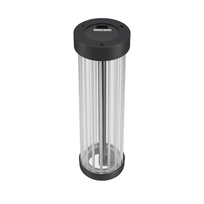 Clear acrylic tube table lamp with black metal base and top.