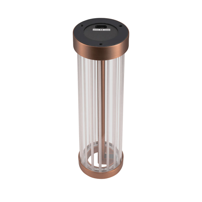 Freestanding cylindrical lamp with clear glass shade and copper-colored metal base and accents.