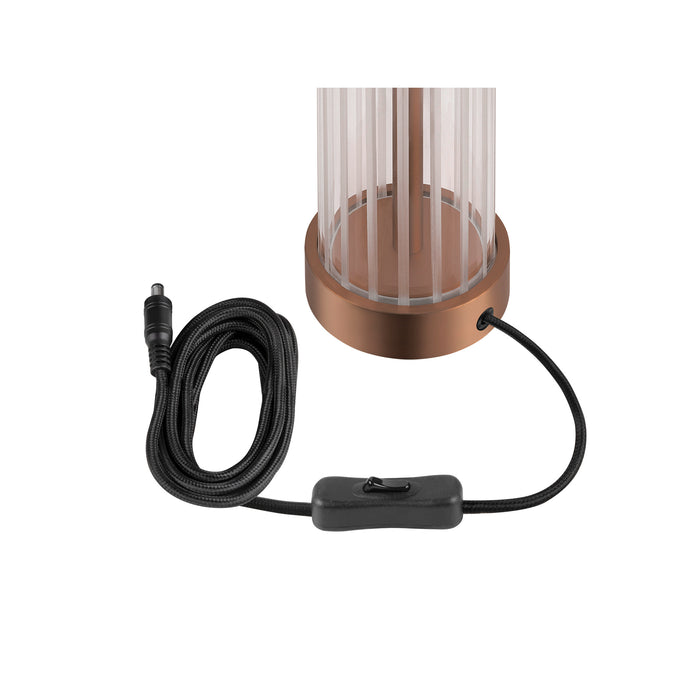 Table lamp with clear glass shade, copper-finish metal base, and black cord with switch.