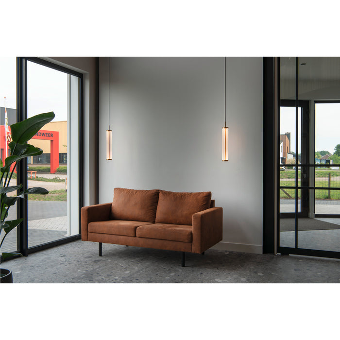 Brown faux leather sofa with black metal legs, and two hanging glass and metal pendant lights.
