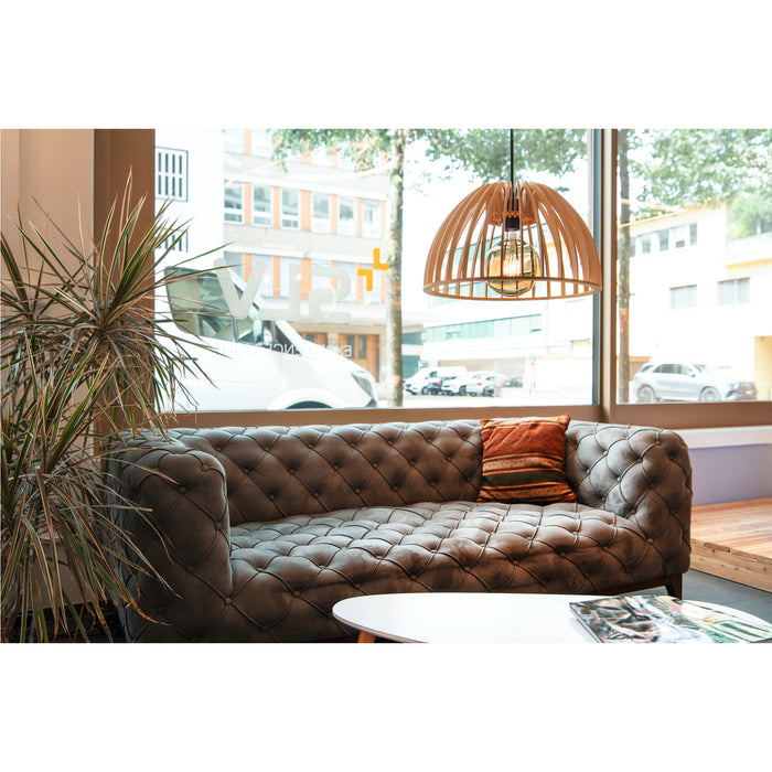 Wood pendant light fixture, natural finish, hanging over a grey tufted sofa in a modern living room.