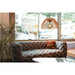 Wood pendant light fixture, natural finish, hanging over a grey tufted sofa in a modern living room.