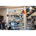 Copper pendant light fixture with a glossy finish, hanging in a wine shop.