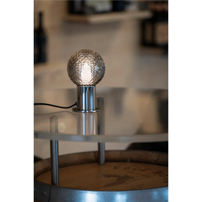 Textured glass globe table lamp with a polished chrome base.