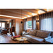 Living room with gray textured fabric sofa, wood walls, and black pendant light.