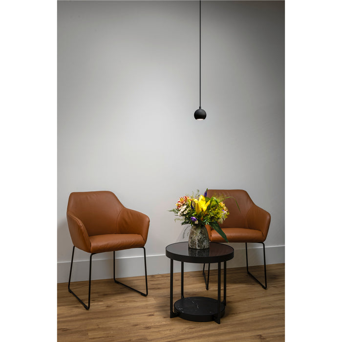 Black pendant light fixture, brown leather chairs, and black marble-top side table with flowers.