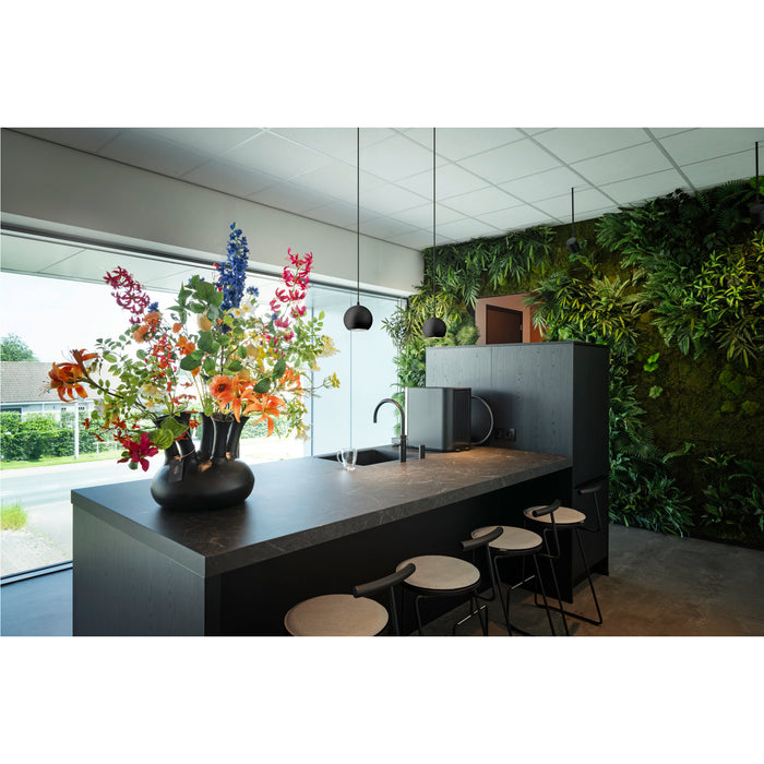 Modern kitchen island with dark marble countertop, black faucet, pendant lights, and stools.