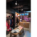 Clothing store interior with wood table, white pendant lights, and neon sign.