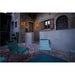 Metal outdoor chairs, light green finish, on brick patio with stone building and wall-mounted sconces.