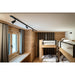 Wood bunk beds with black metal frame, white linens, and black track lighting in a wood-paneled room.