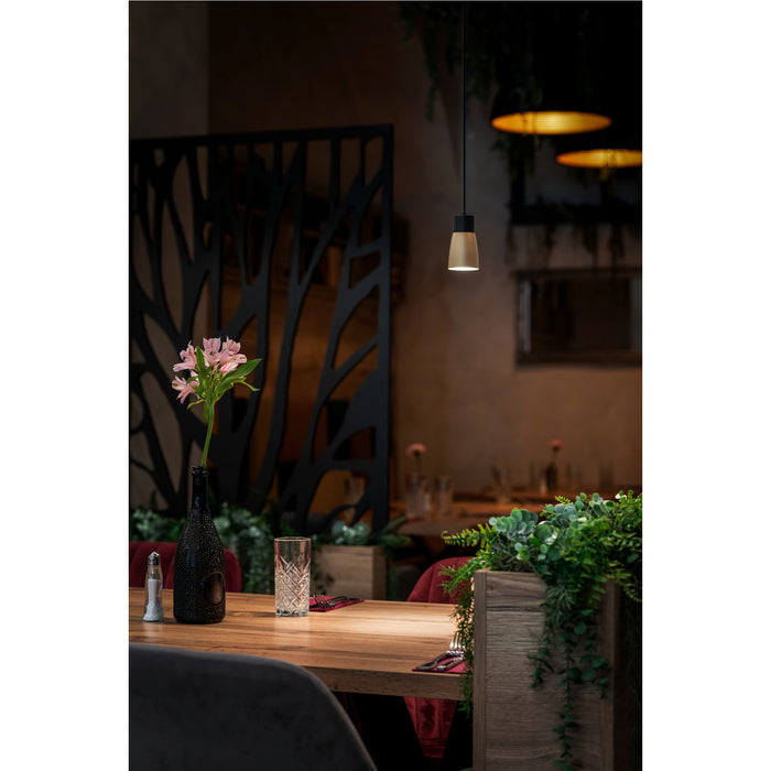 Hanging pendant light fixture, metal and wood, with black and gold finish, over restaurant table.