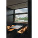 Dining nook with marble-look table, four gold velvet chairs with black metal legs, and three copper pendant lights.