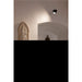 Interior with plaster wall relief of Madonna and Child, black ceiling-mounted spotlight.