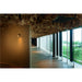 Hallway with wood floor, paper ceiling art, and wall-mounted spotlight.