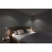 Bedroom with wall-mounted white reading lights illuminating the bed.