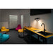 Modern break room with black sink and faucet on wood and metal cart, colorful beanbag chairs, and black track lighting.