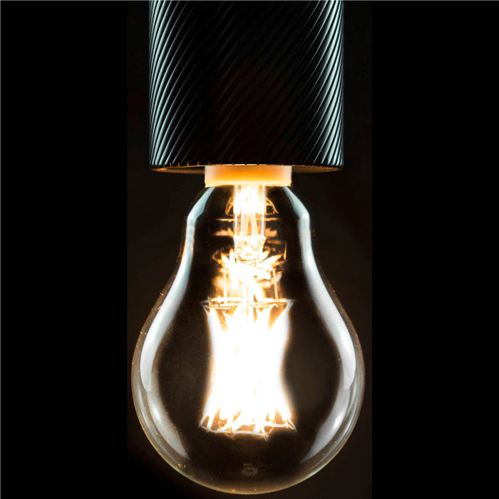 Hanging clear glass light bulb with black textured metal fixture.