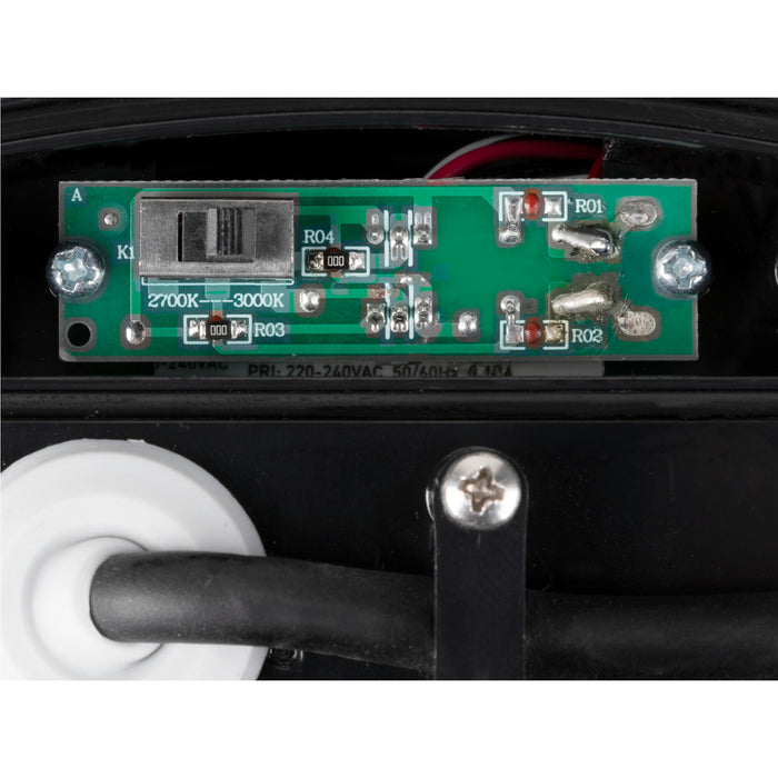 Close-up of a green circuit board with a 2700K-3000K switch, mounted inside a black fixture.