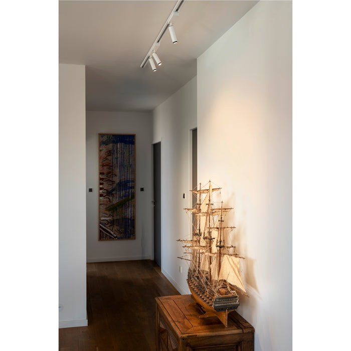 White track lighting fixture with three adjustable spotlights, ceiling mounted.