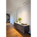 White ceiling-mounted track lighting over a dark wood sideboard with a light countertop and gold legs.